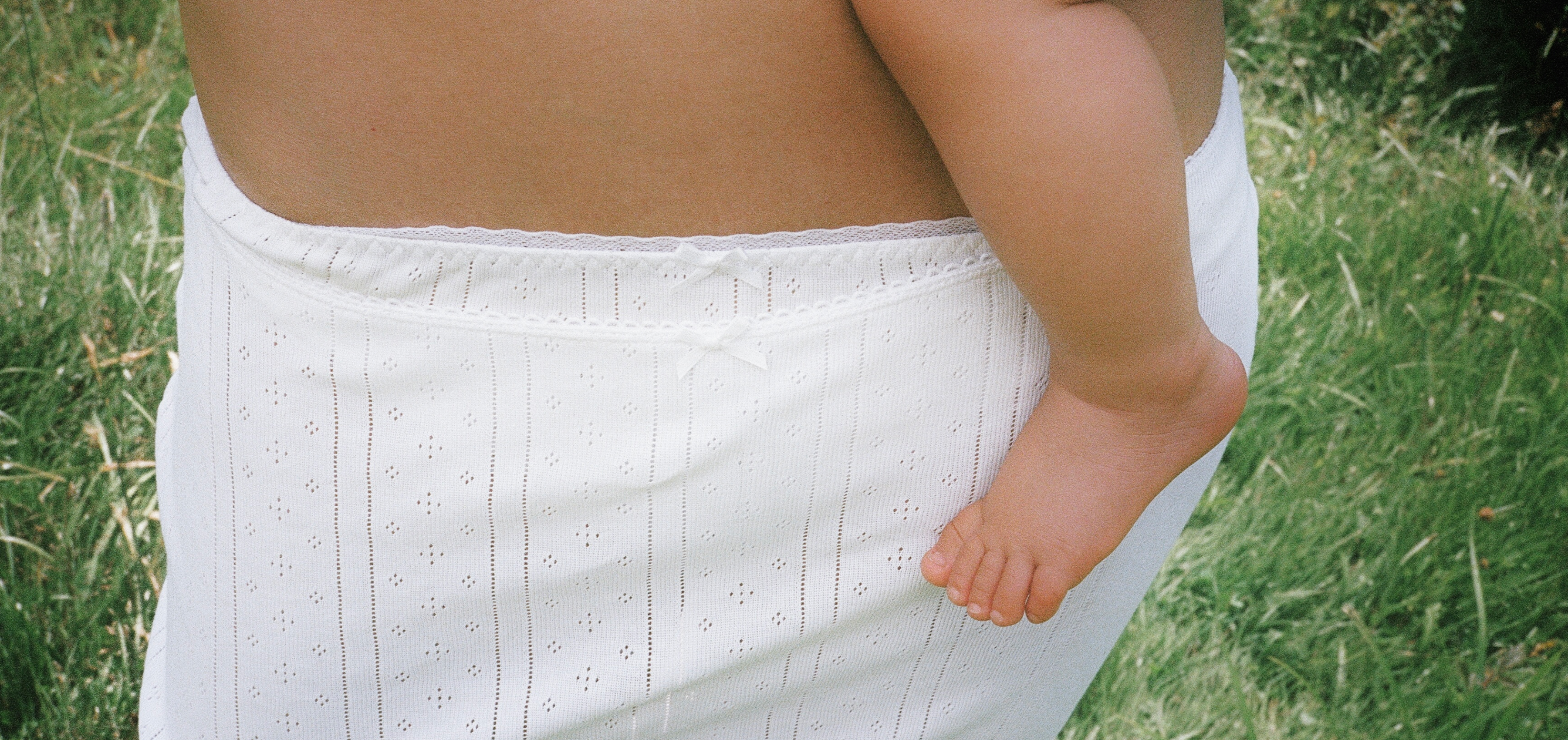 Cou Cou Intimates model carrying a baby